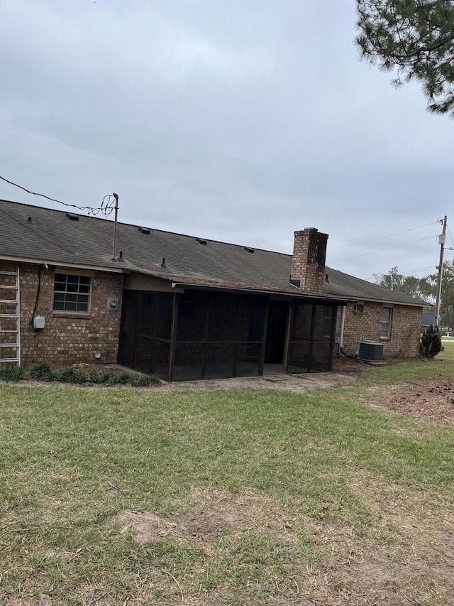 back of house with a yard and a sunroom