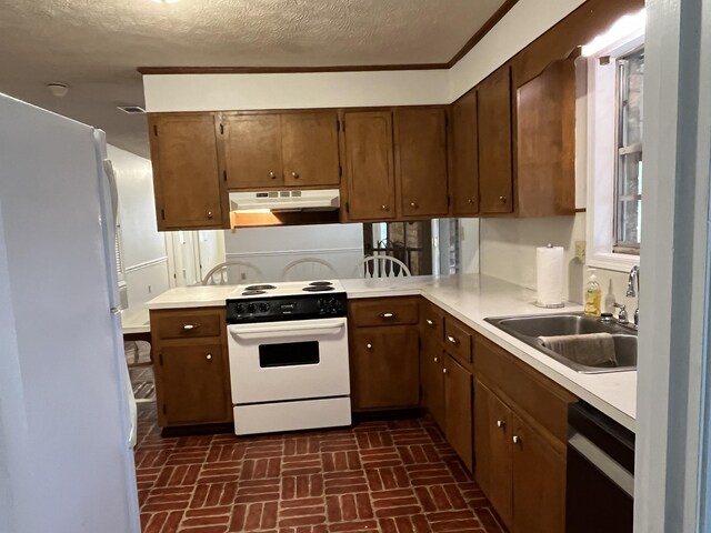 kitchen with a textured ceiling, white appliances, sink, and ornamental molding