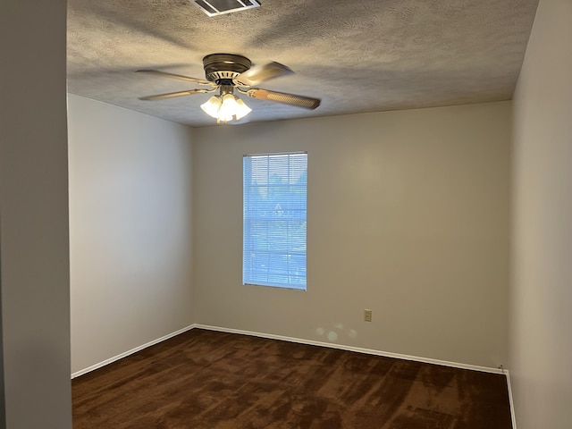 empty room featuring dark colored carpet, a textured ceiling, and ceiling fan