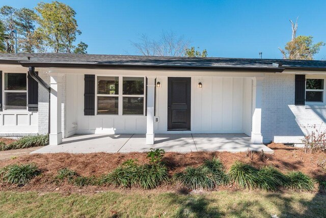 back of property featuring covered porch