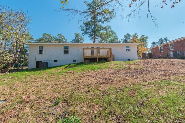 back of property featuring a lawn, central AC unit, and a deck