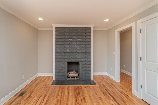 unfurnished living room with a fireplace, light wood-type flooring, and ornamental molding