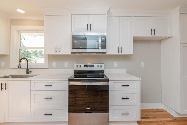 kitchen with white cabinets, appliances with stainless steel finishes, and sink