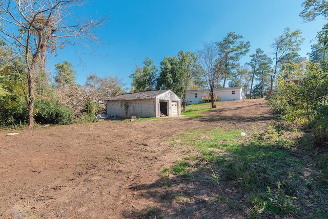 view of yard with a garage and an outbuilding