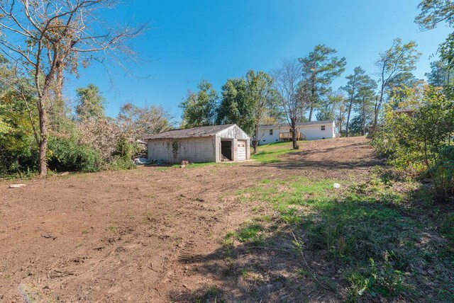 view of yard with a garage and an outbuilding