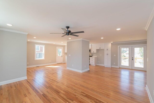 unfurnished living room with ceiling fan, light hardwood / wood-style floors, crown molding, and french doors