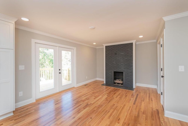 unfurnished living room with french doors, light hardwood / wood-style flooring, a brick fireplace, and crown molding