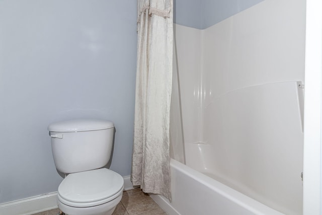 full bath with tile patterned flooring, baseboards, shower / bath combo, and toilet