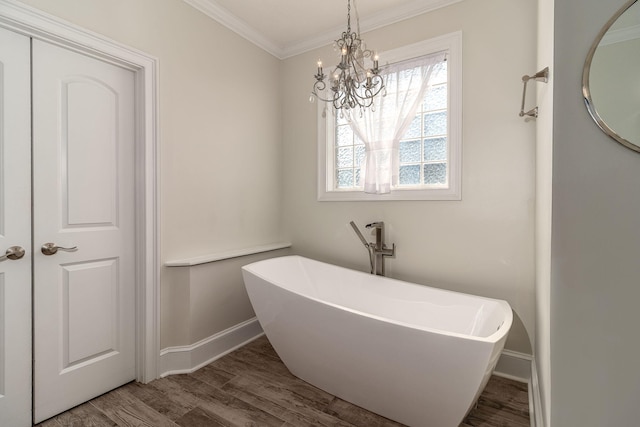 full bathroom featuring crown molding, baseboards, a freestanding bath, and wood finished floors