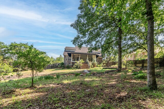 view of yard with a porch and fence