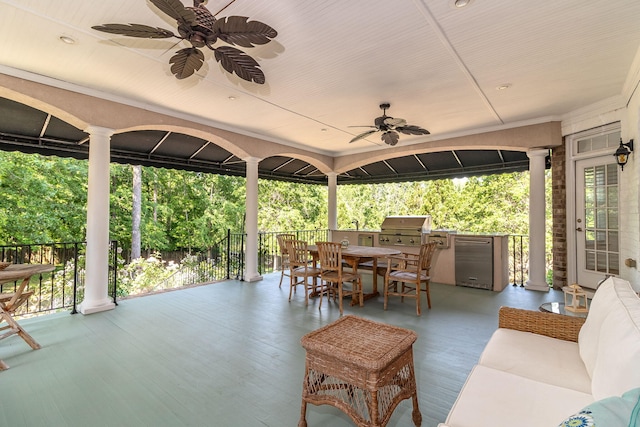 view of patio with outdoor dining area, a ceiling fan, grilling area, and an outdoor kitchen