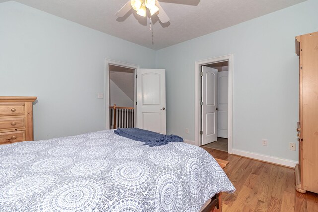 bedroom with light wood-style floors, baseboards, and ceiling fan