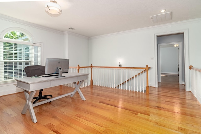 home office with crown molding, baseboards, visible vents, and light wood-style flooring