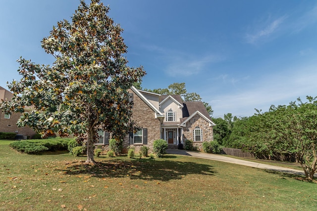 view of front of property featuring a front lawn and stone siding