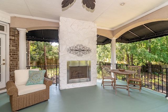 view of patio featuring a porch and an outdoor stone fireplace