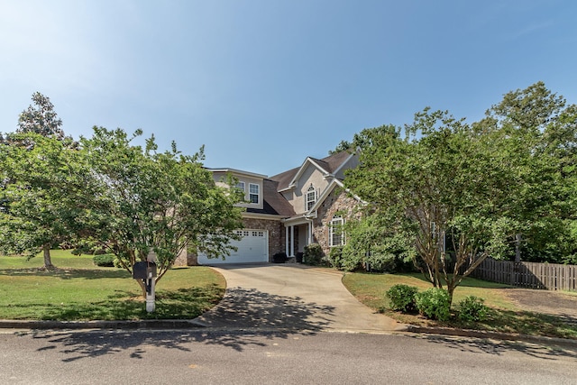 view of front of home with fence, an attached garage, brick siding, a front yard, and concrete driveway