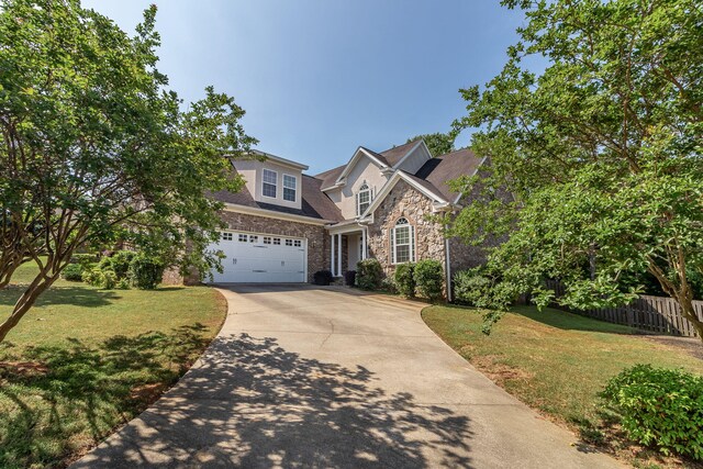 traditional-style home with fence, driveway, a front yard, and a garage
