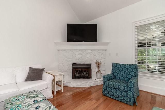 living room with lofted ceiling, wood finished floors, and a fireplace