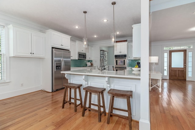 kitchen featuring stainless steel appliances, decorative backsplash, and light wood-type flooring