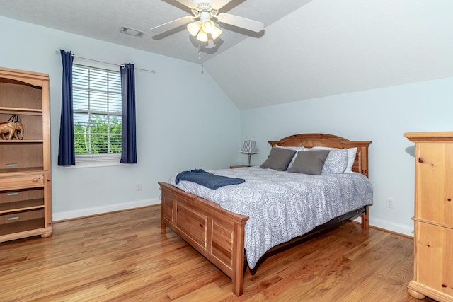 bedroom featuring ceiling fan, light wood finished floors, baseboards, lofted ceiling, and visible vents