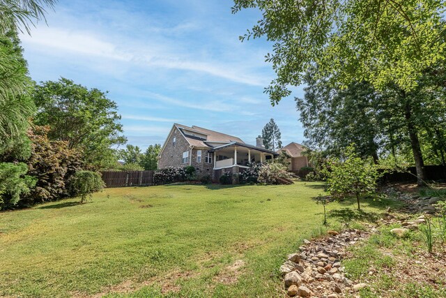 view of yard featuring fence and a sunroom