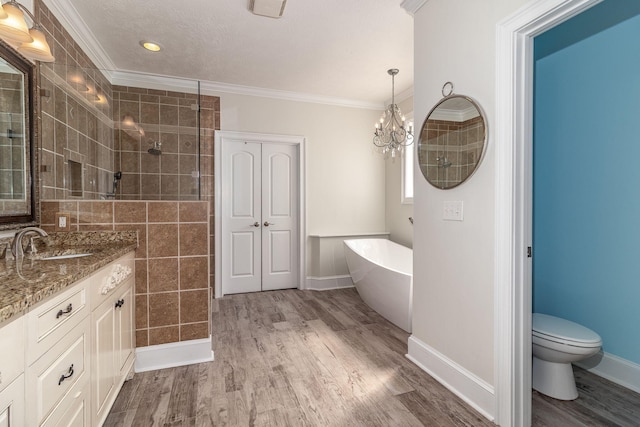 bathroom with a tile shower, wood finished floors, vanity, a chandelier, and a soaking tub