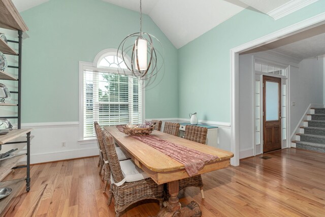 dining room featuring stairs, a notable chandelier, a wealth of natural light, and light wood-style flooring