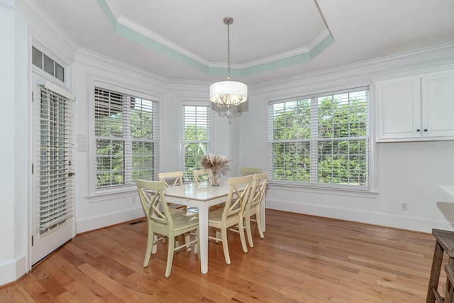 dining room featuring baseboards, an inviting chandelier, light wood-style flooring, and a tray ceiling