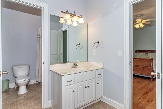 bathroom with ceiling fan, tile patterned flooring, vanity, toilet, and baseboards