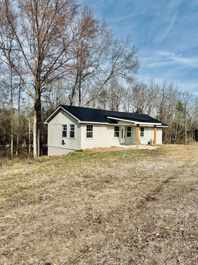 rear view of property featuring a patio and a lawn