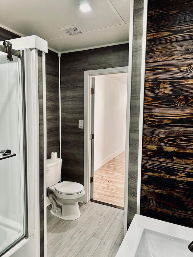 bathroom featuring wood-type flooring and toilet