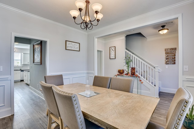 dining room featuring crown molding, dark hardwood / wood-style flooring, and a chandelier