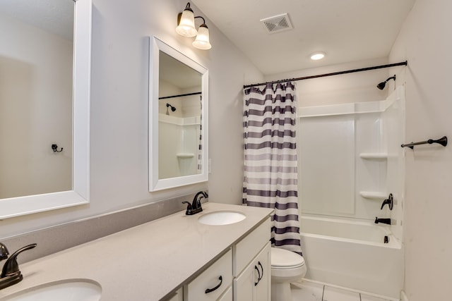 bathroom featuring double vanity, visible vents, toilet, and a sink