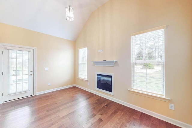 1190 Tralee Dr, Beech Island, SC 29842 - unfurnished living room featuring wood finished floors, a glass covered fireplace, and high vaulted ceiling