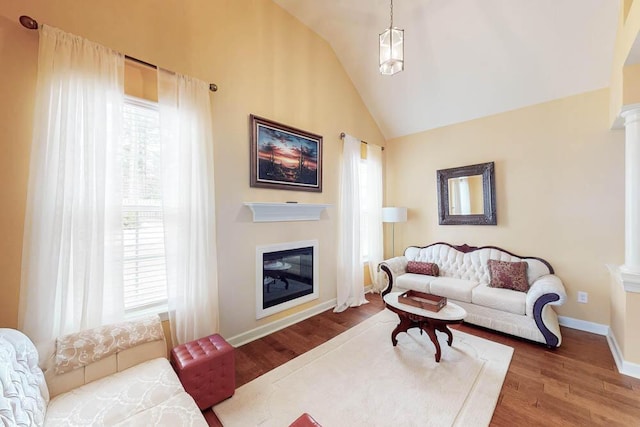 living room featuring a wealth of natural light, lofted ceiling, and wood finished floors