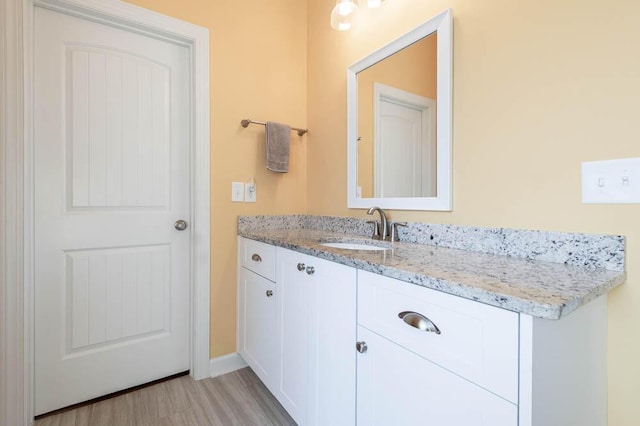 bathroom featuring vanity, baseboards, and wood finished floors