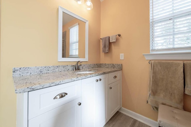 bathroom with vanity, baseboards, and wood finished floors