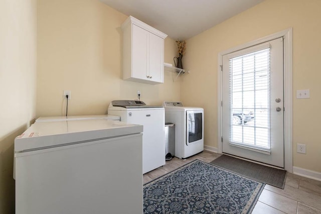 laundry area with washing machine and clothes dryer, cabinet space, and baseboards