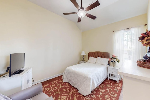 bedroom with wood finished floors, a ceiling fan, baseboards, and vaulted ceiling