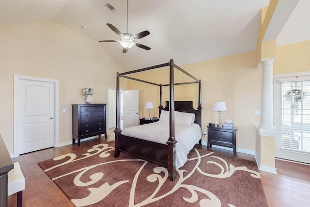 bedroom with wood finished floors, visible vents, ornate columns, and high vaulted ceiling