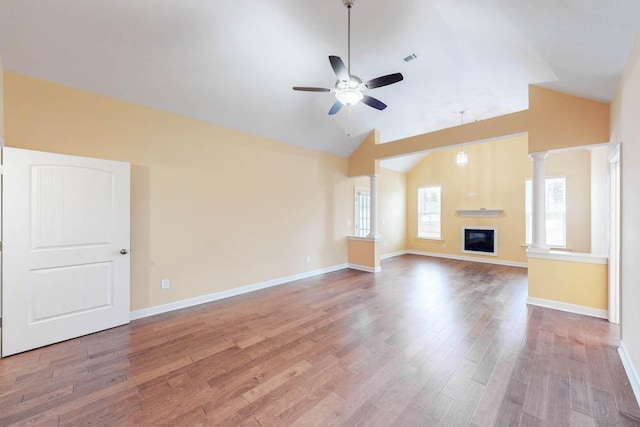 1190 Tralee Dr, Beech Island, SC 29842 - unfurnished living room featuring vaulted ceiling, a ceiling fan, wood finished floors, a glass covered fireplace, and decorative columns