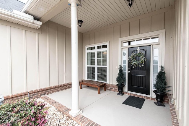 doorway to property featuring brick siding and board and batten siding