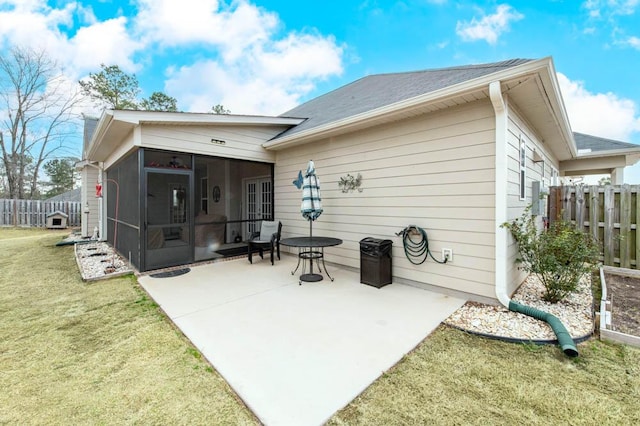 back of house featuring a patio area, a lawn, fence, and a sunroom