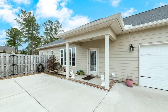 view of patio / terrace with a garage and fence