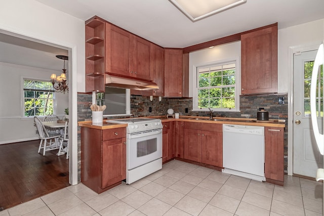 751 Lancaster Rd, Augusta, GA 30909 - kitchen with white appliances, under cabinet range hood, plenty of natural light, and decorative backsplash