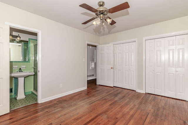 751 Lancaster Rd, Augusta, GA 30909 - unfurnished bedroom featuring hardwood / wood-style floors, two closets, baseboards, and a sink