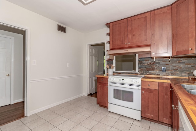 751 Lancaster Rd, Augusta, GA 30909 - kitchen with white appliances, under cabinet range hood, backsplash, and brown cabinets