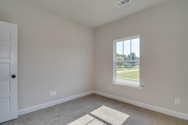 carpeted spare room with visible vents and baseboards