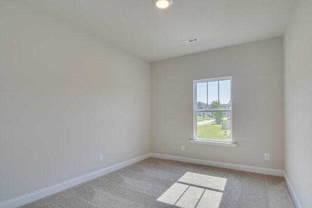 spare room featuring visible vents, baseboards, and carpet