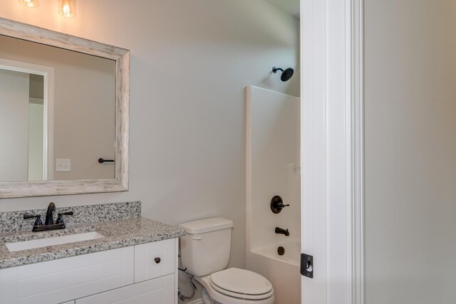 bathroom with toilet, vanity, and bathing tub / shower combination